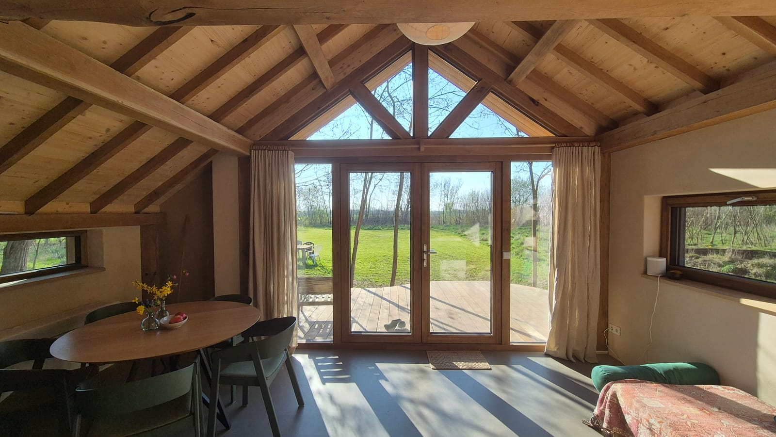 Woonkamer met grote glaswand en uitzicht op het bos
