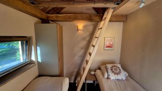 Slaapkamer met twee losse bedden met daarboven de slaapvide met 1 bed