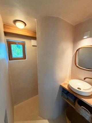 Badkamer met koperen kraan en leemstuc wanden